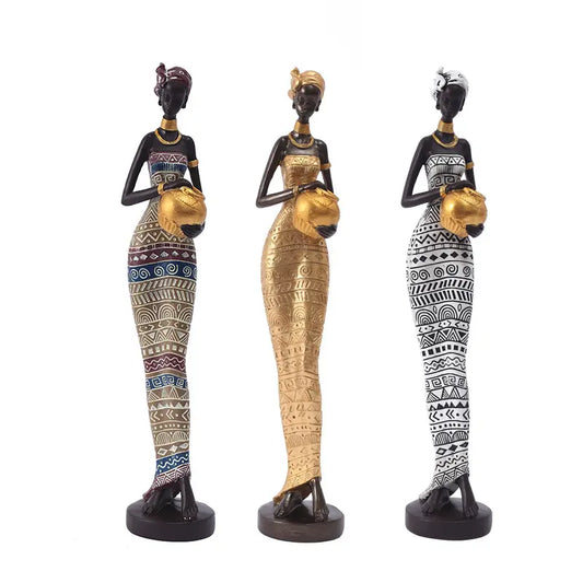 Set of three African resin statues of women holding gold pots, in tribal-patterned dresses: colorful, gold, and black-and-white