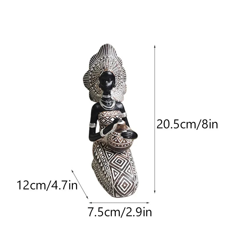 Seated African resin woman statue in black and white tribal dress with headpiece, 20.5cm tall, holding pot