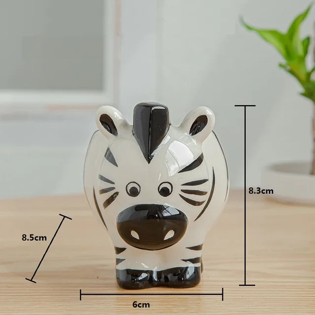 Ceramic zebra-shaped planter holding a green succulent, displayed on a wooden surface.
