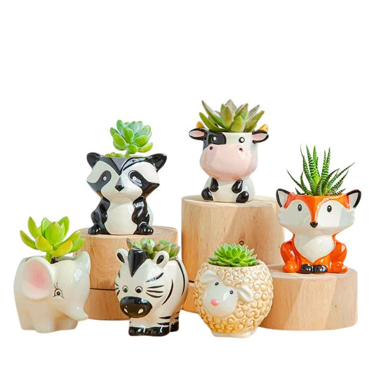 Ceramic animal planters shaped like a fox, zebra, elephant, raccoon, sheep, and cow, each holding a succulent plant on a wooden shelf


