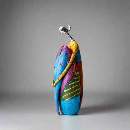 Vibrant abstract resin figurine with metallic head, wrapped in colorful textured patterns of blue, purple, and green – modern artistic home decor

